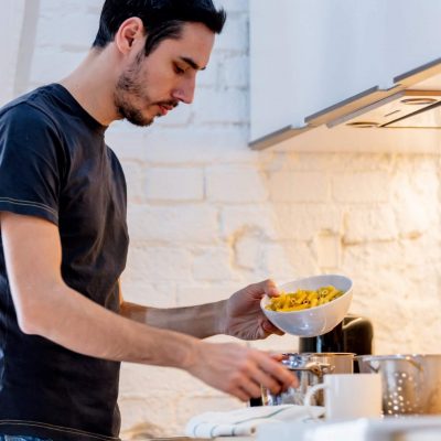 young-man-in-black-shirt-cooking-at-kitchen-in-hom-2022-01-12-05-26-18-utc (1)
